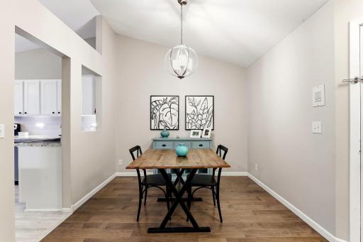 Inviting dining area with wood flooring, vaulted ceiling, modern pendant lighting, and an open connection to the kitchen and living spaces.