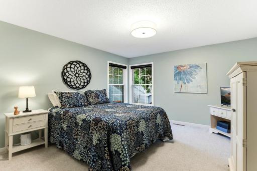 Spacious second bedroom featuring soft carpeting, two windows for abundant natural light, and plenty of room for furnishings.