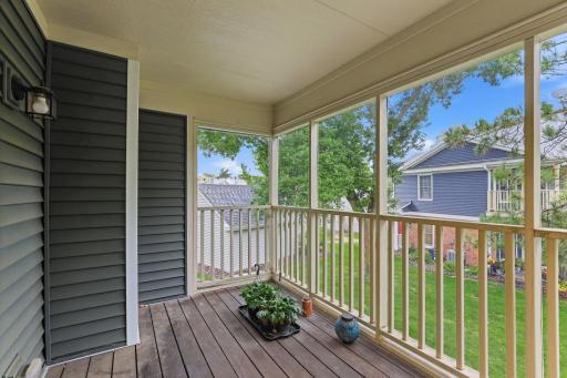 Private covered balcony featuring a durable, pet-friendly screen enclosure and peaceful views of the landscaped community.