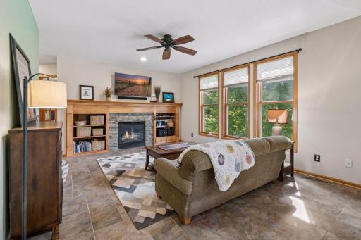 Stone gas fireplace framed by built-in shelving