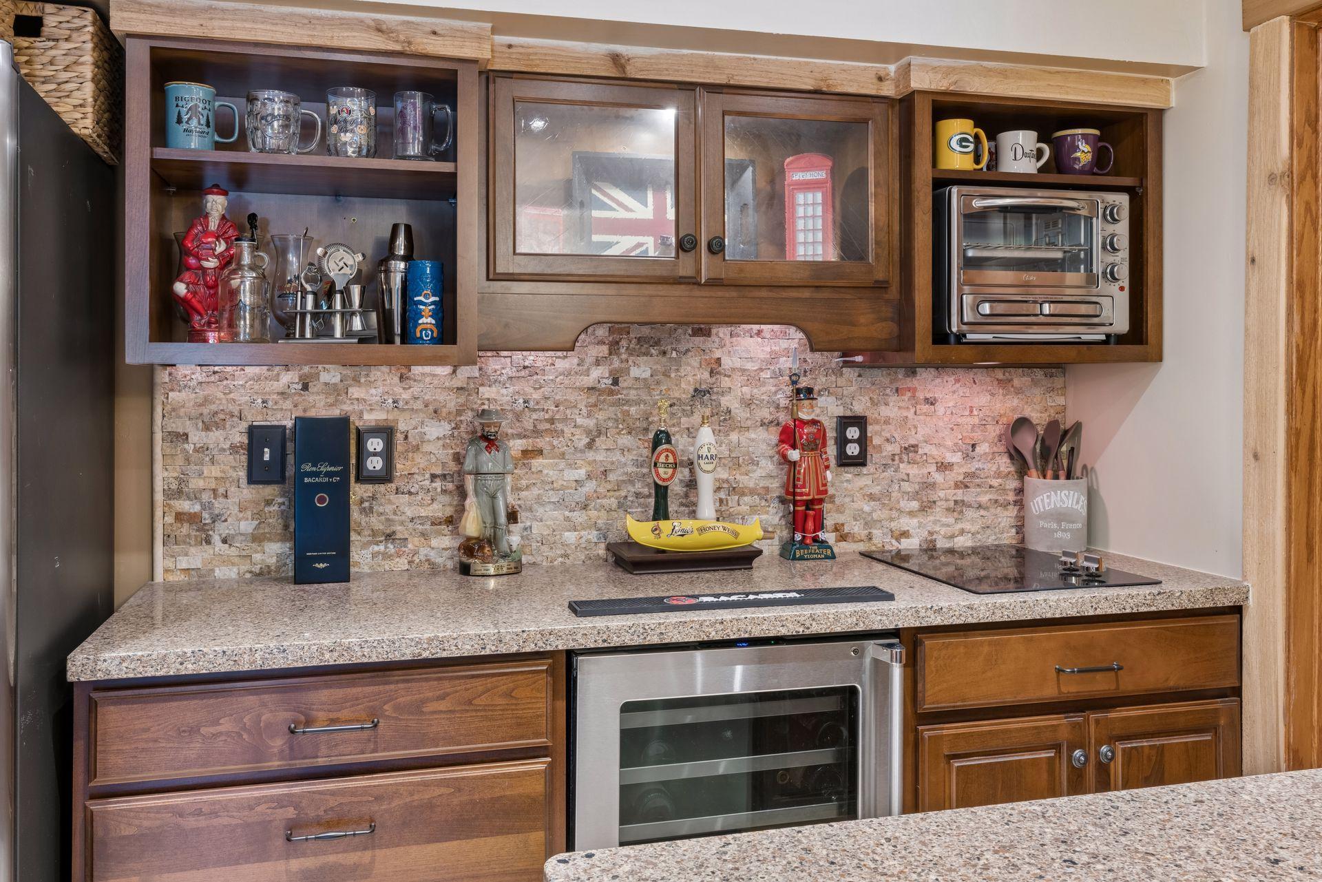 Lower level bar with stone backsplash and beverage cooler