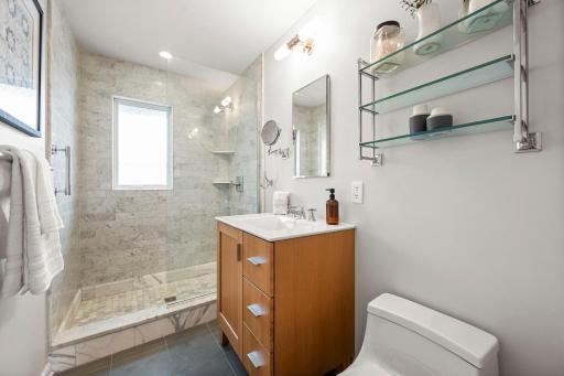 Beautiful bathroom with walk-in shower, marble tiled surround and floor, tiled bathroom floor