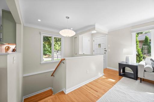 Coat closet, wide stairway to lower level with large window for great natural light, custom blind