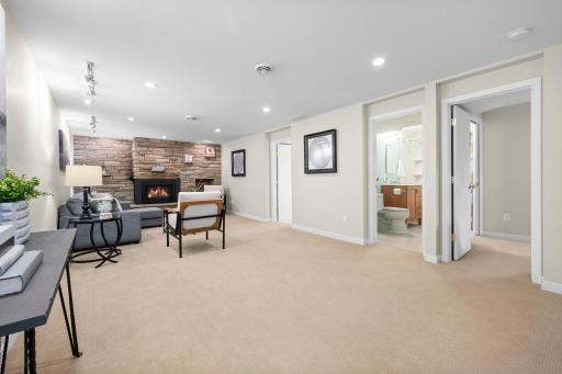 Large lower level family room with freshly cleaned carpet, gas fireplace