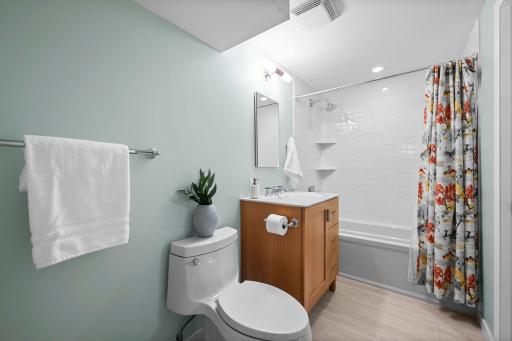Clean crisp bathroom with tiled shower and tiled floor