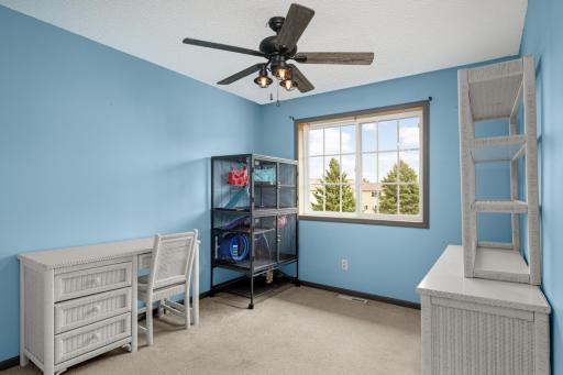 Good-sized second Bedroom with a large window and ceiling fan.