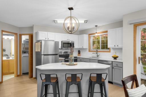 Kitchen offers enameled cabinets, gorgeous counter tops in quartz and spacious center island with snack bar seating.
