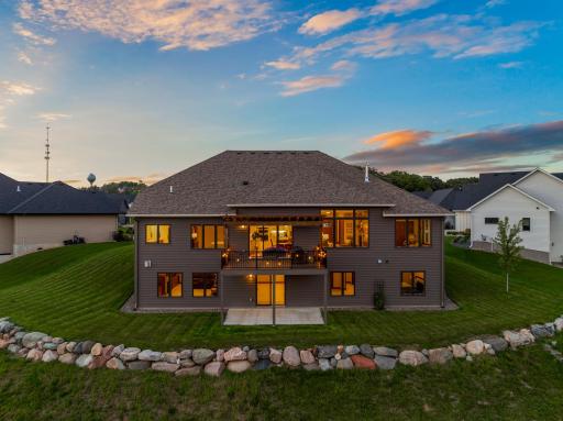 Impressive rear elevation highlights the homeâs walkout design, elevated deck, expansive windows, and beautifully maintained yardâperfect for indoor-outdoor living and entertaining.