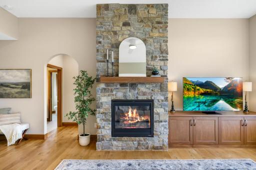 The dramatic stone fireplace creates a warm focal point in the great room, while custom cabinetry keeps entertainment stylishly integrated into the space.
