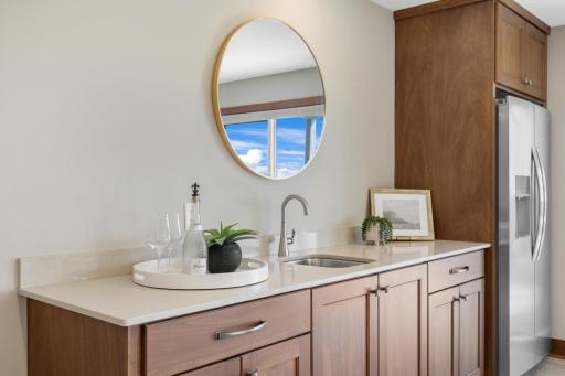 A dedicated beverage center with sink, generous cabinetry and full-size refrigerator keeps drinks and refreshments close at handâperfect for hosting family and friends.