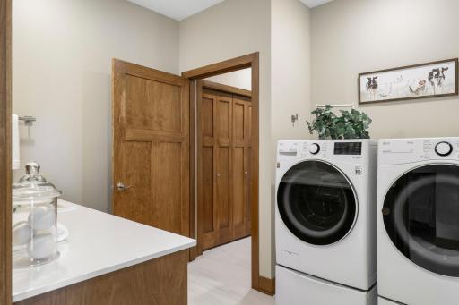 Thoughtfully designed for everyday convenience, the main-level laundry provides a direct pass-through between the primary suite and the mudroom/garage.