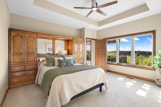 Wake up to expansive views in this spacious primary suite, featuring a tray ceiling, abundant natural light, and a peaceful connection to the outdoors.
