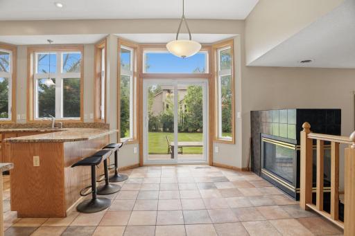 Morning coffee never looked so good. This bright breakfast nook opens through sliding glass to the patio, a tiled three sided fireplace warming the space just steps away.