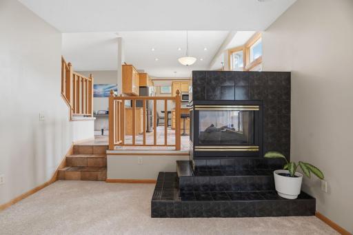 This multi level layout keeps everyone connected, the same three sided fireplace glowing beneath a vaulted kitchen ceiling just a few tiled steps away.