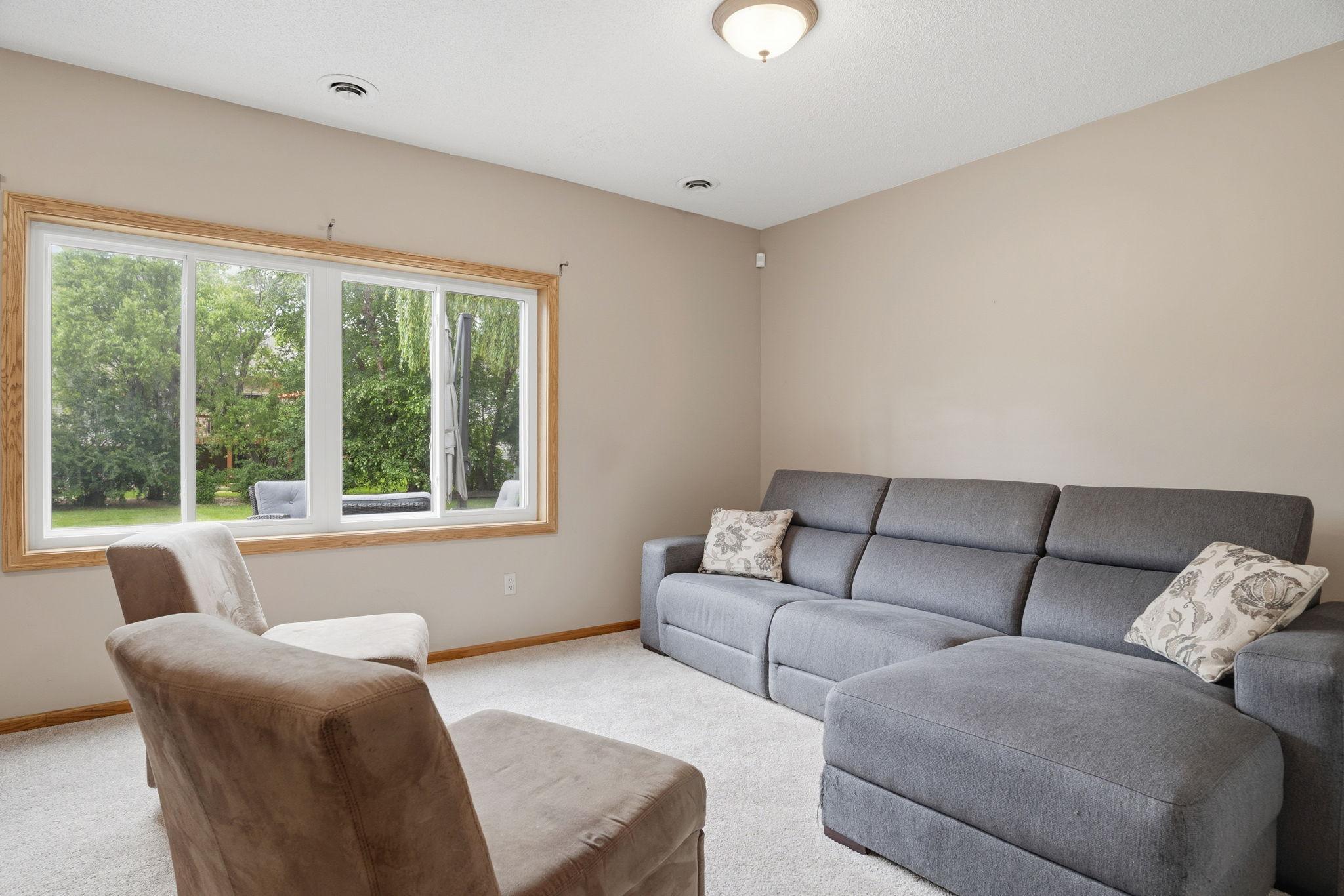 Picture family game night in this lower level retreat, a picture window framing mature trees for a quiet escape from the everyday.