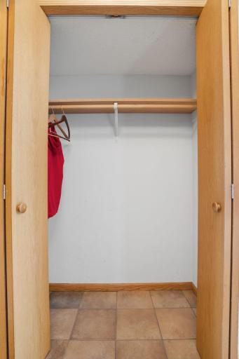 Extra storage right off the entry. This deep tiled closet keeps the foyer's warm, welcoming tone flowing from floor to shelf.