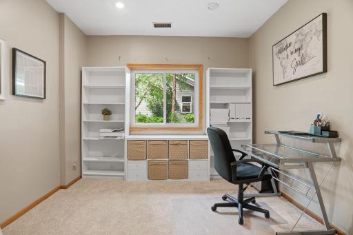 Remote work made easy. This home office features built in shelving flanking a garden window, a bright, flexible space with views of mature trees outside.