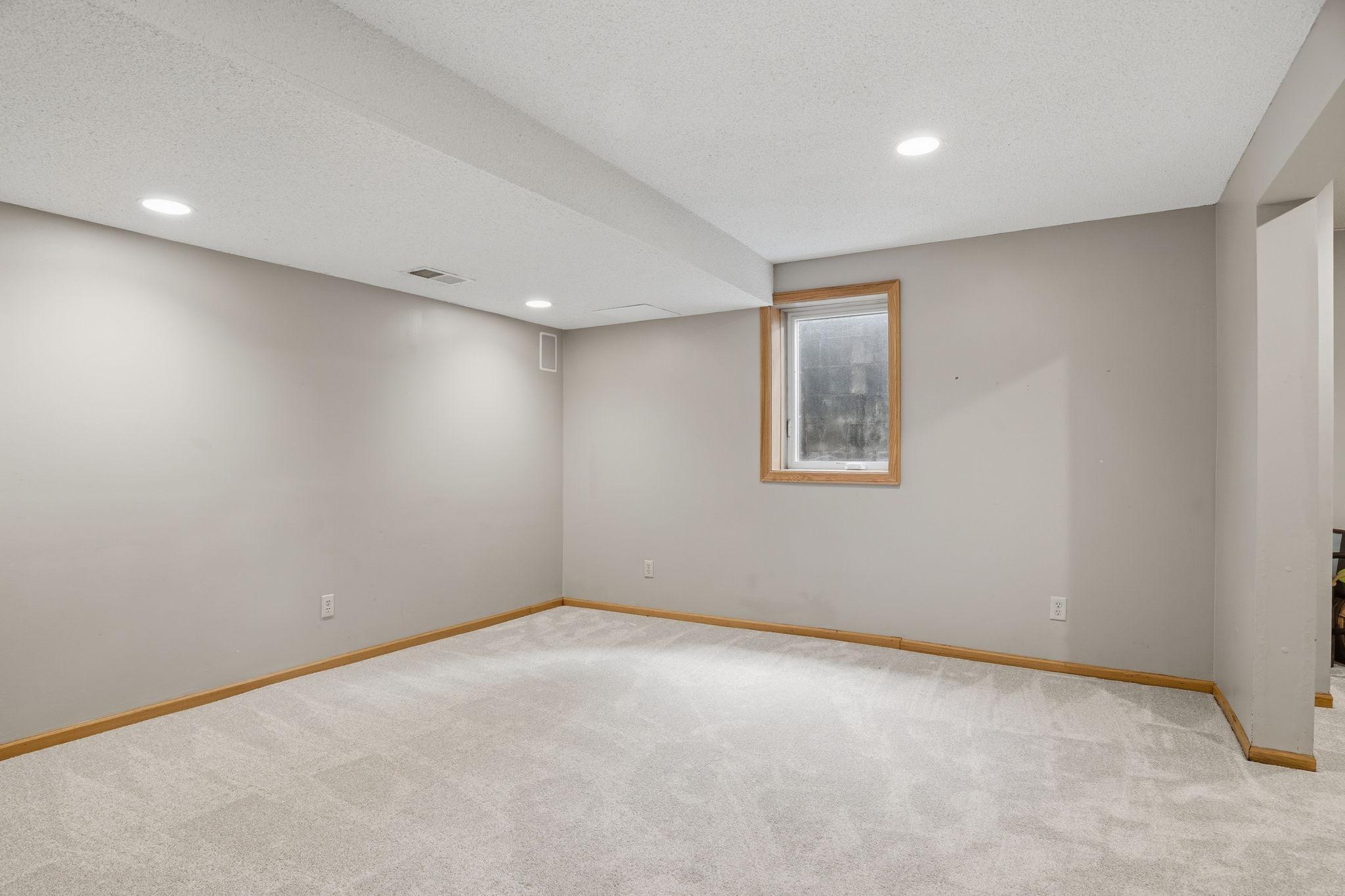 A single window brings daylight into this unfinished corner of the lower level, matching oak trim leaving room for buyers to add their own finishing touch.