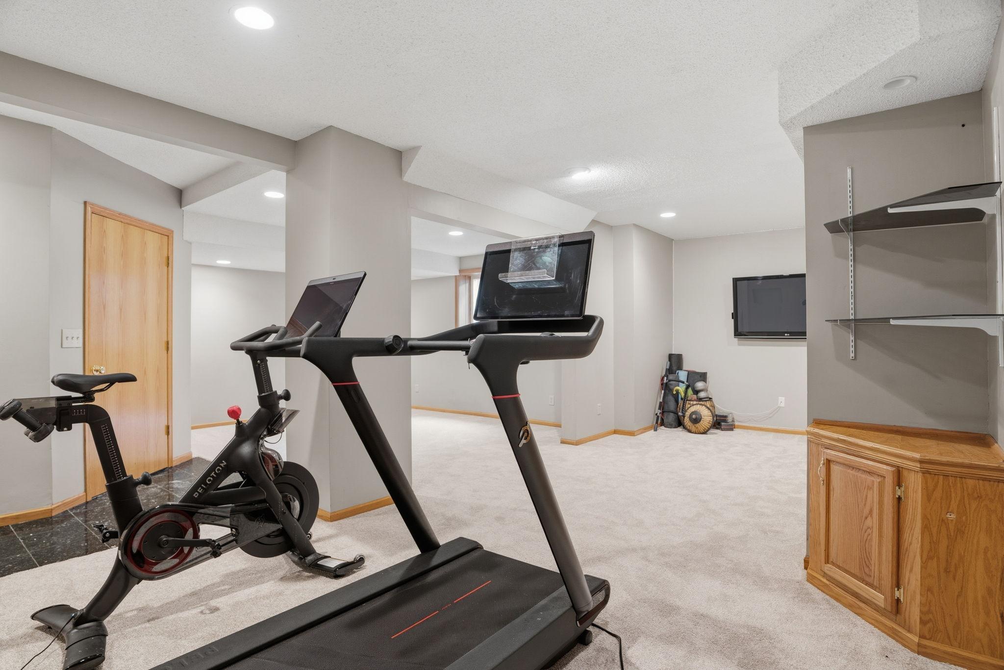 This flexible lower level space is wired and ready for a mounted screen, recessed lighting and an angled ceiling framing a room built for movie nights.