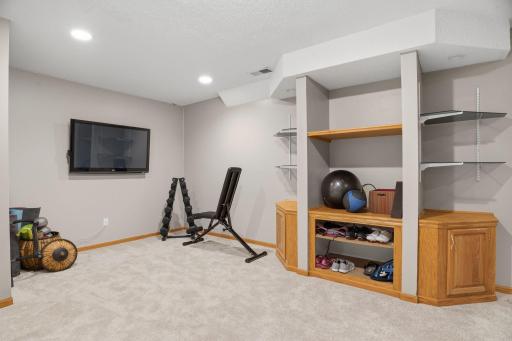 Organized living starts here. Open shelving and cubby storage wrap a central support column, turning this lower level corner into the ultimate flex space.