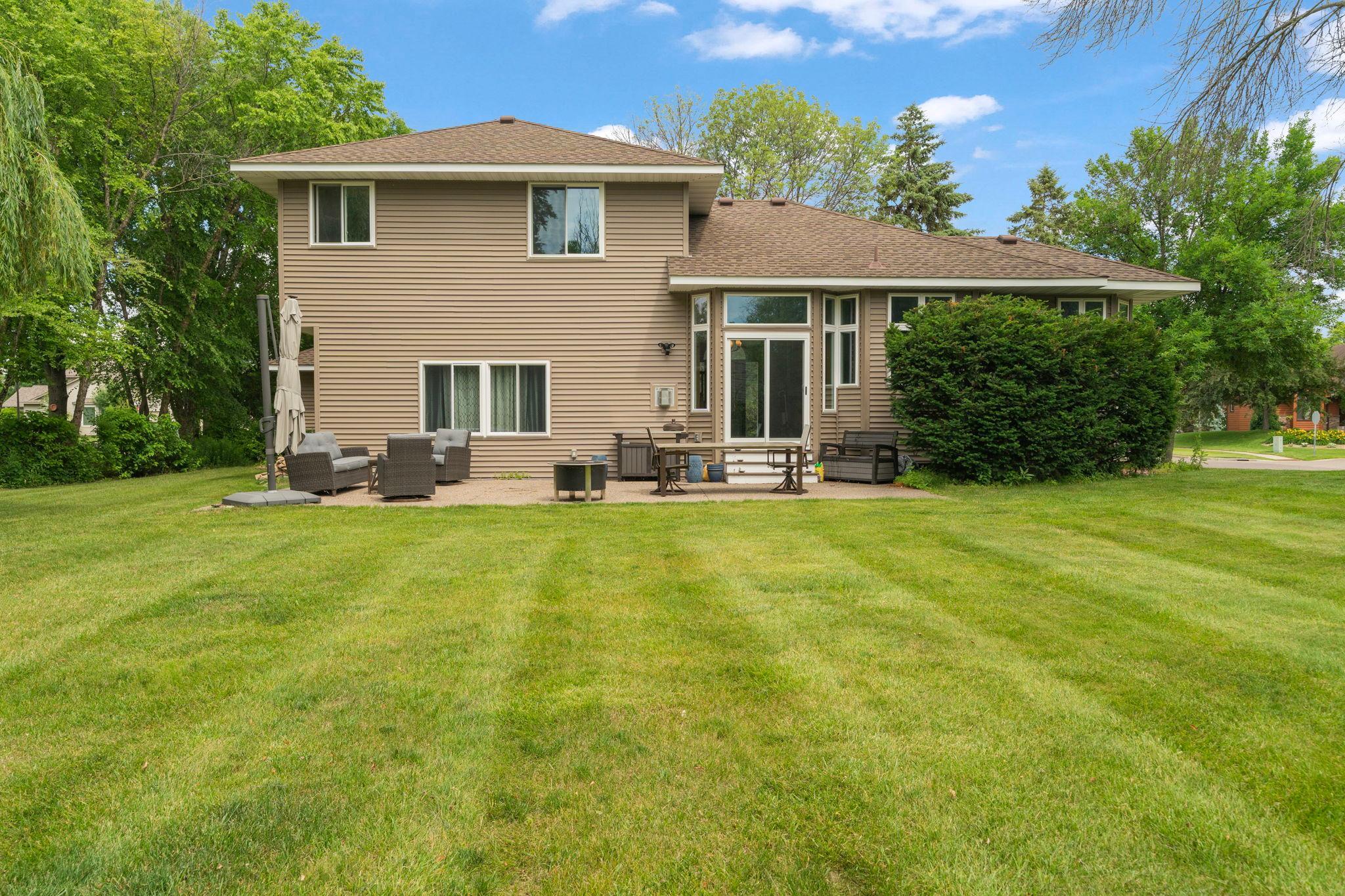 Tall corner windows brighten the back of the home, a patio and expansive private lawn stretching beyond the sliding door for effortless indoor outdoor living.