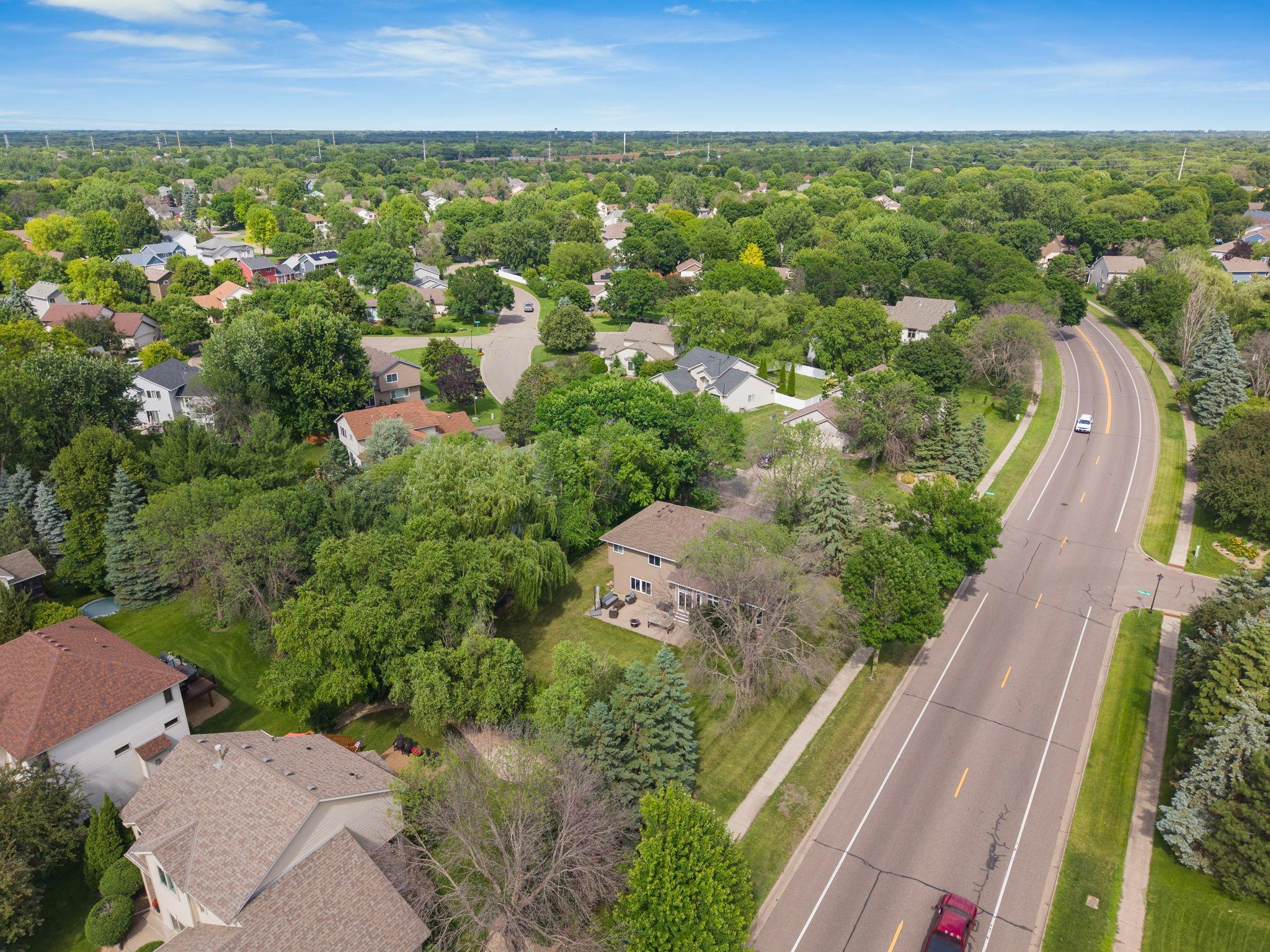 This tree bordered backyard sits peacefully just off the main road, buffered by dense landscaping for everyday privacy.