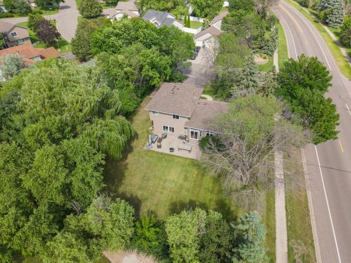 This bird's eye view says it all, a rectangular backyard and patio framed by a deep border of mature trees on a lot built for outdoor living.
