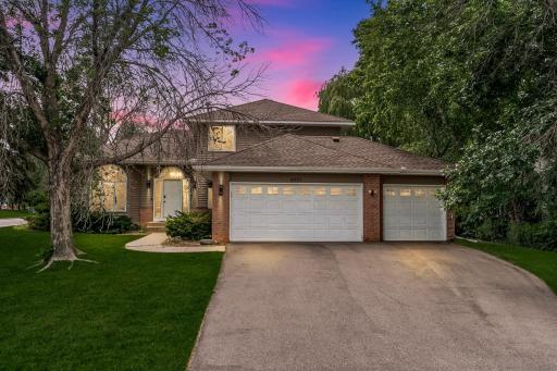 Welcome to 8901 Dunbar. Mature trees frame the drive. Brick and cedar catch the last of the light. Three garage bays wait like an open hand. This could be home, before you even step inside.