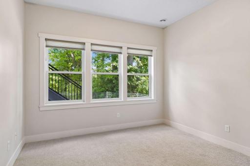 Lower-level guest bedroom with wooded views.