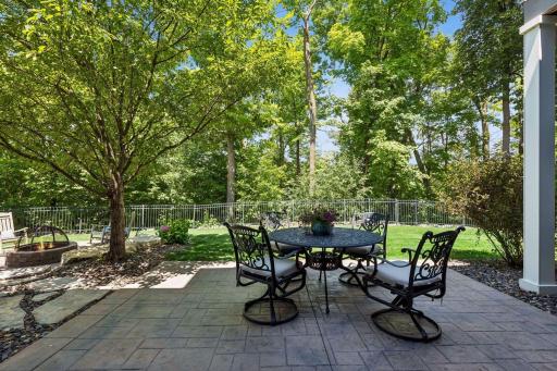 Private backyard patio surrounded by mature trees.