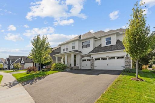 Front Exterior: Striking curb appeal with a welcoming covered entry and beautifully landscaped setting.