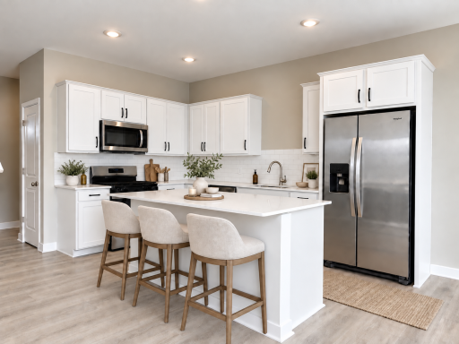 Beautiful open-concept kitchen featuring a large center island, quartz countertops, stainless steel appliances, gray shaker cabinets, subway tile backsplash, recessed lighting, and warm wood floors. *Photo of similar home. Virtually staged.
