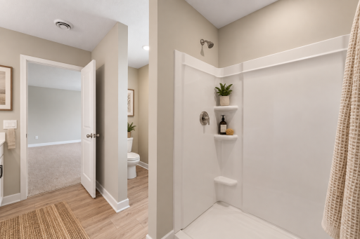 Primary shower and toilet. *Photo of similar home. Virtually staged.