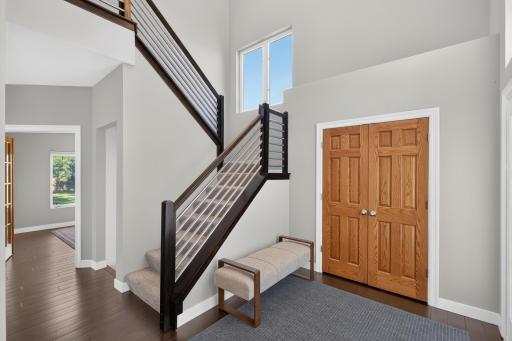 Gorgeous two-story foyer with a beautiful modern staircase and coat closet.