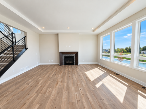 Spacious great room with abundant natural light, modern fireplace, and large windows overlooking the surrounding area.