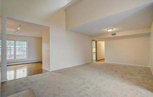 Living room view into dining room and hallway to laundry room and bedrooms.