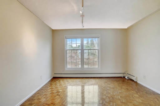Formal dining area accented by warm wood floors, offering an inviting backdrop for everyday meals and special occasions.