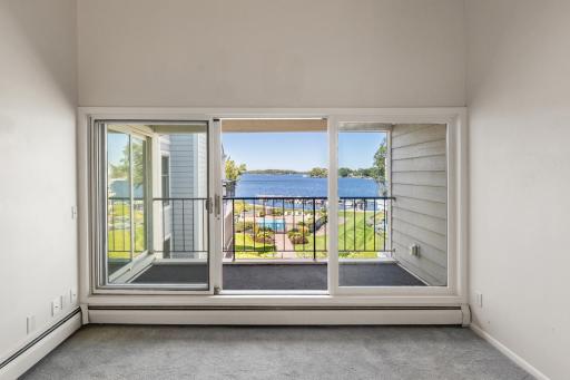 The living room flows effortlessly to the balcony through a large sliding glass door, offering peaceful lake views right outside.