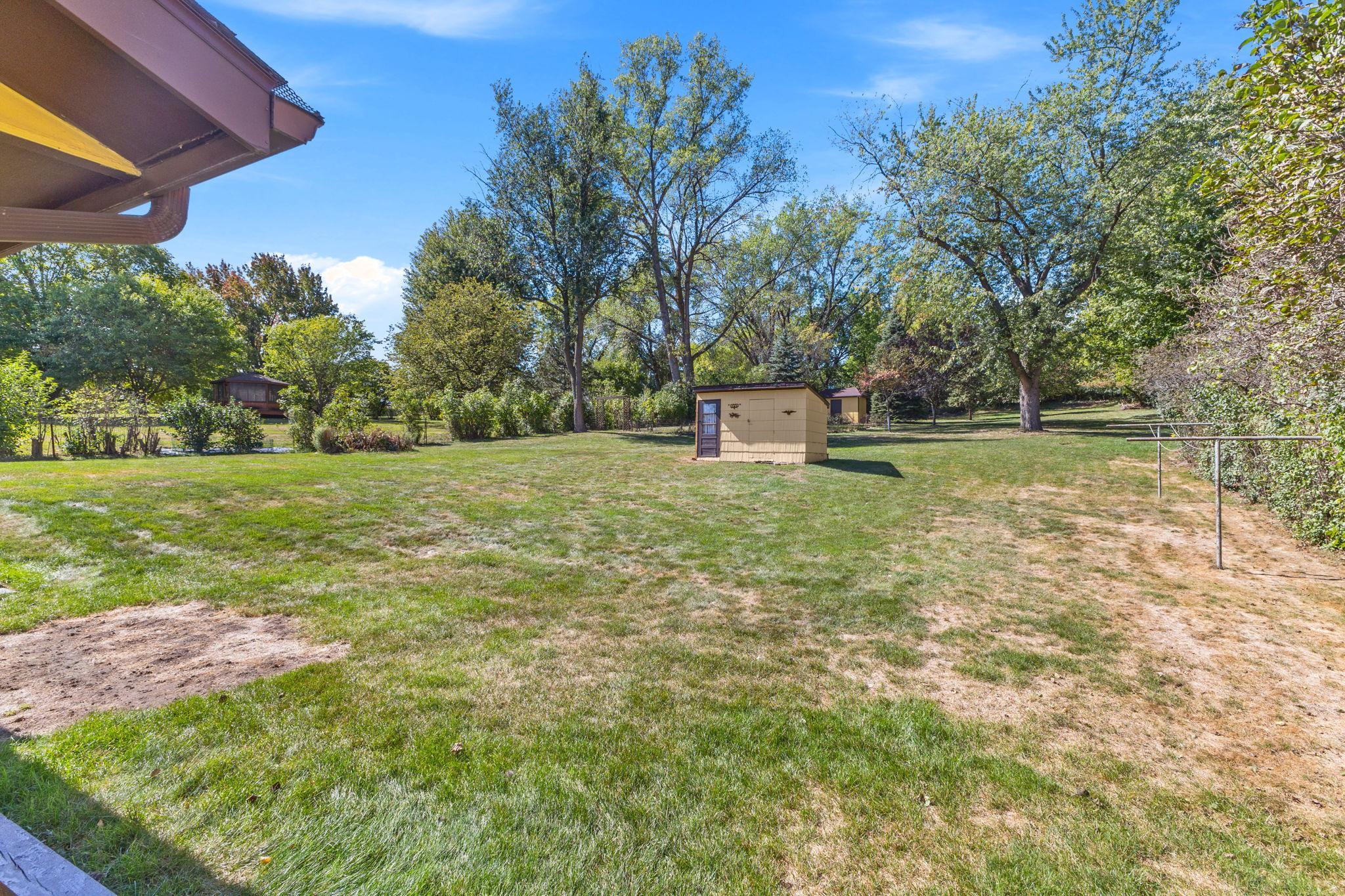 View of the backyard with both storage sheds.