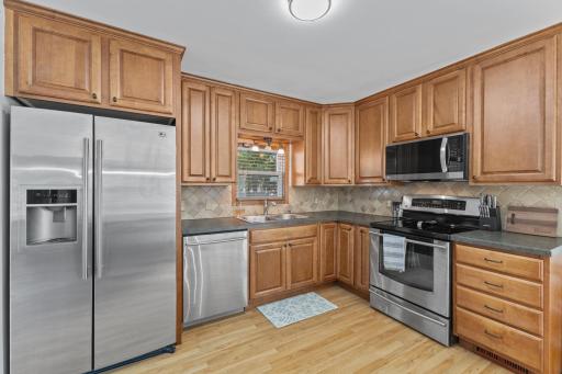 The updated kitchen features custom cabinetry and tile backsplash