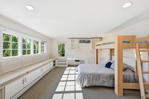 The third upstairs bedroom with a large walk-in closet and cozy storage bench.