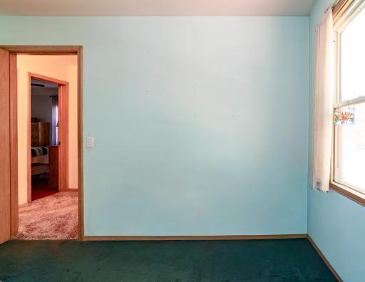 The third main floor bedroom with access to the center hallway and the back door and kitchen.