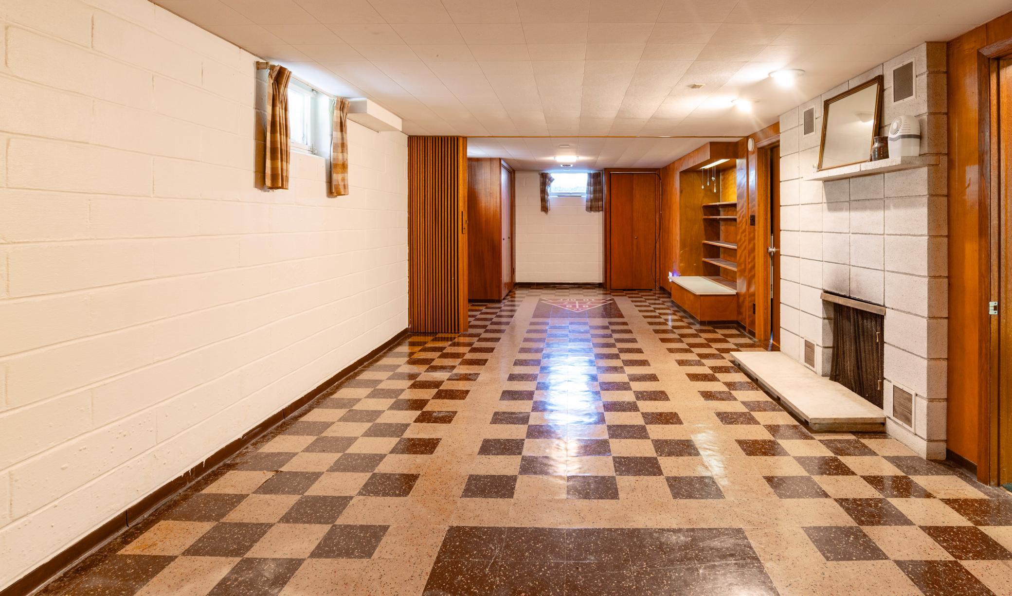 Lower level family room with wood burning fireplace, built in shelving and closets.