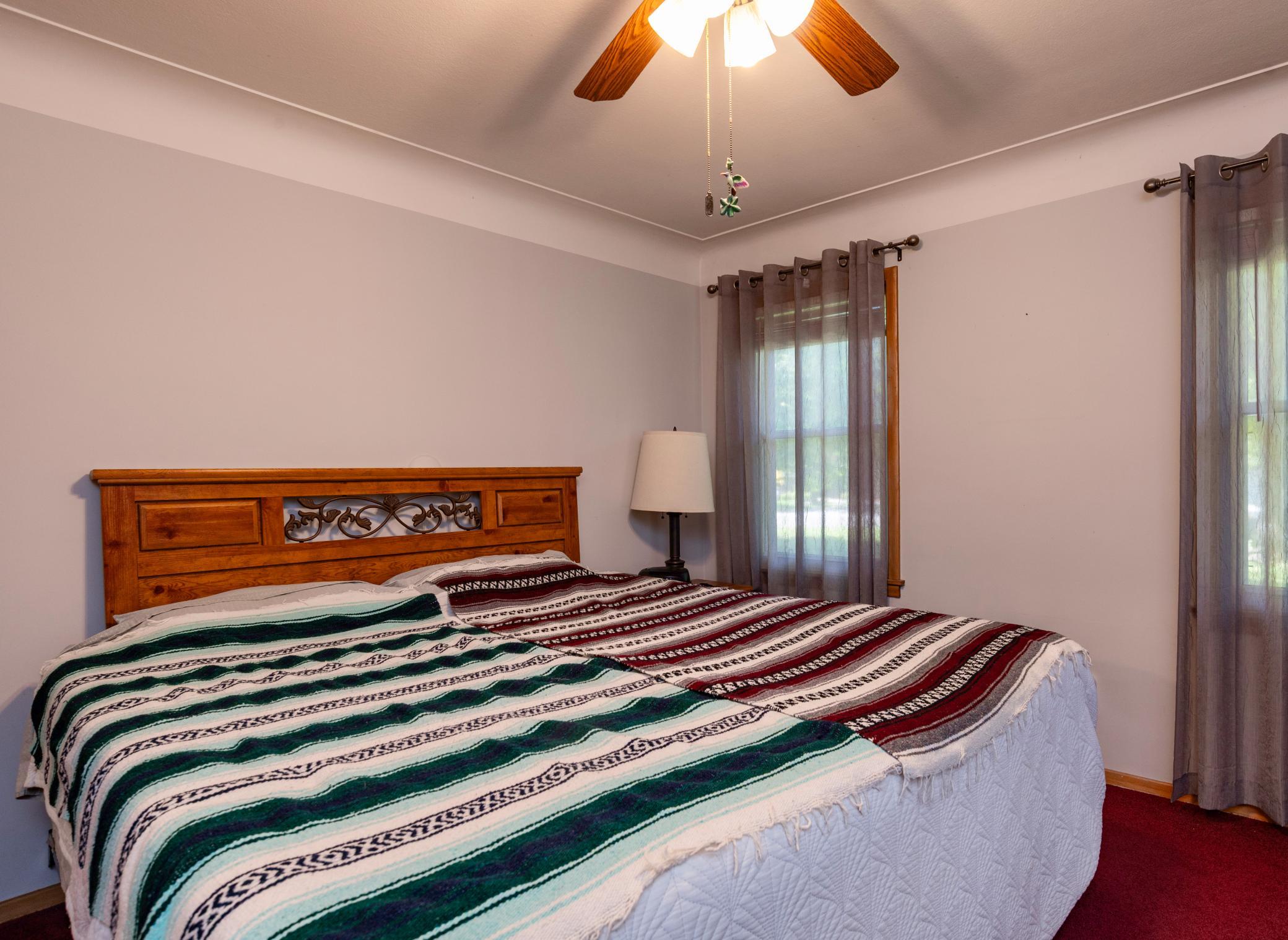 Large primary main floor bedroom with cove ceilings, ceiling fan and enough room for a king size bed.