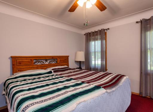 Large primary main floor bedroom with cove ceilings, ceiling fan and enough room for a king size bed.