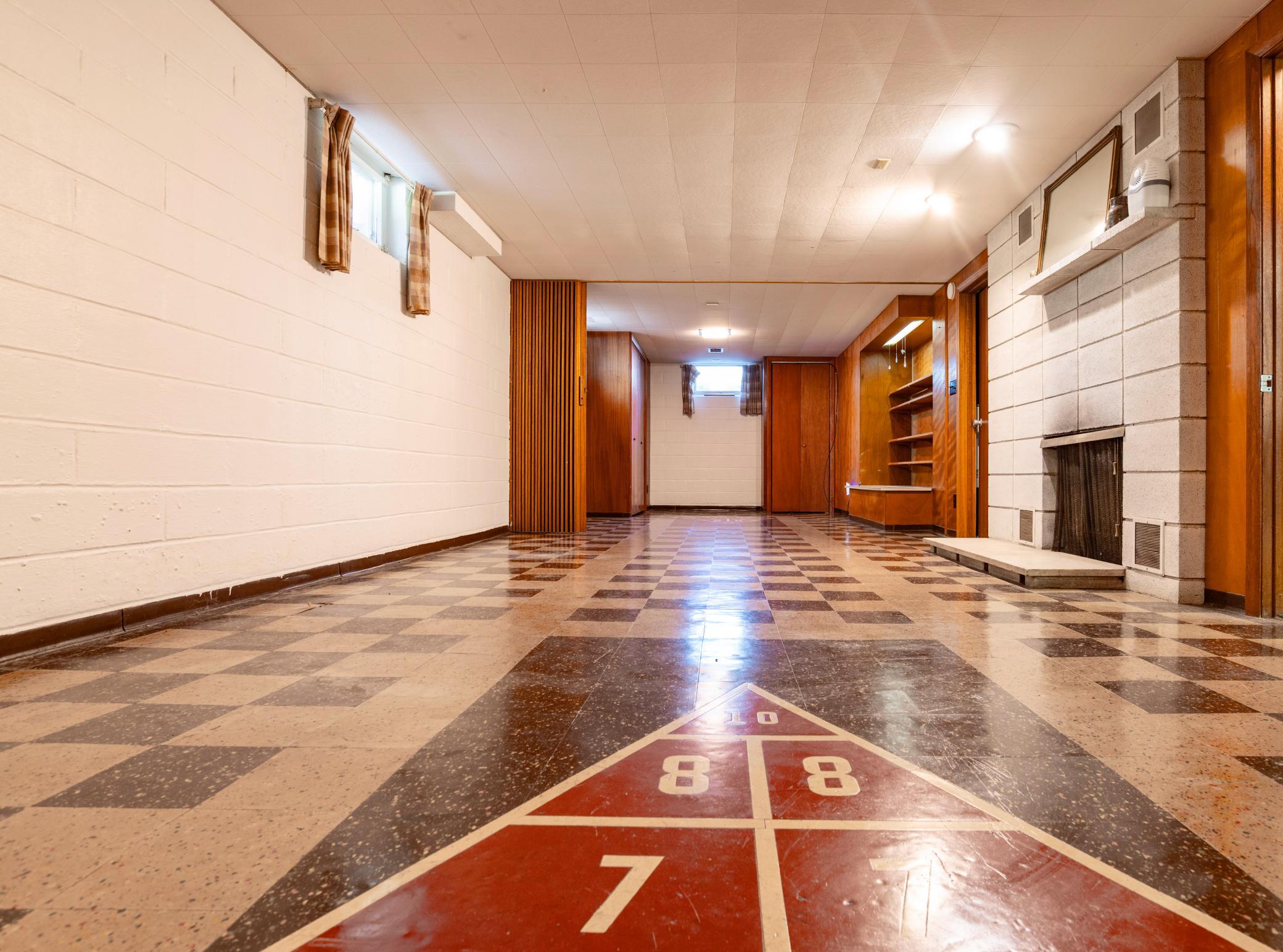 Lower level family room with a game built right into the flooring.