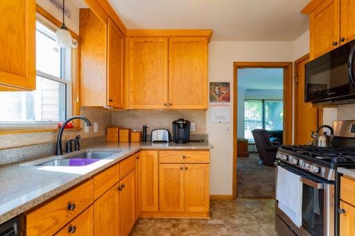 Updated kitchen features light oak cabinets, hard surface counter tops, Gas range and pantry.