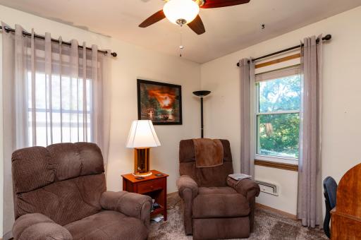 The second main floor bedroom has two windows and is currently being used as an office and TV room.
