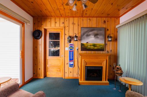 Three season porch with access to garage, patio door to large deck and large west facing windows. Electric fireplace is excluded from the sale of the home.