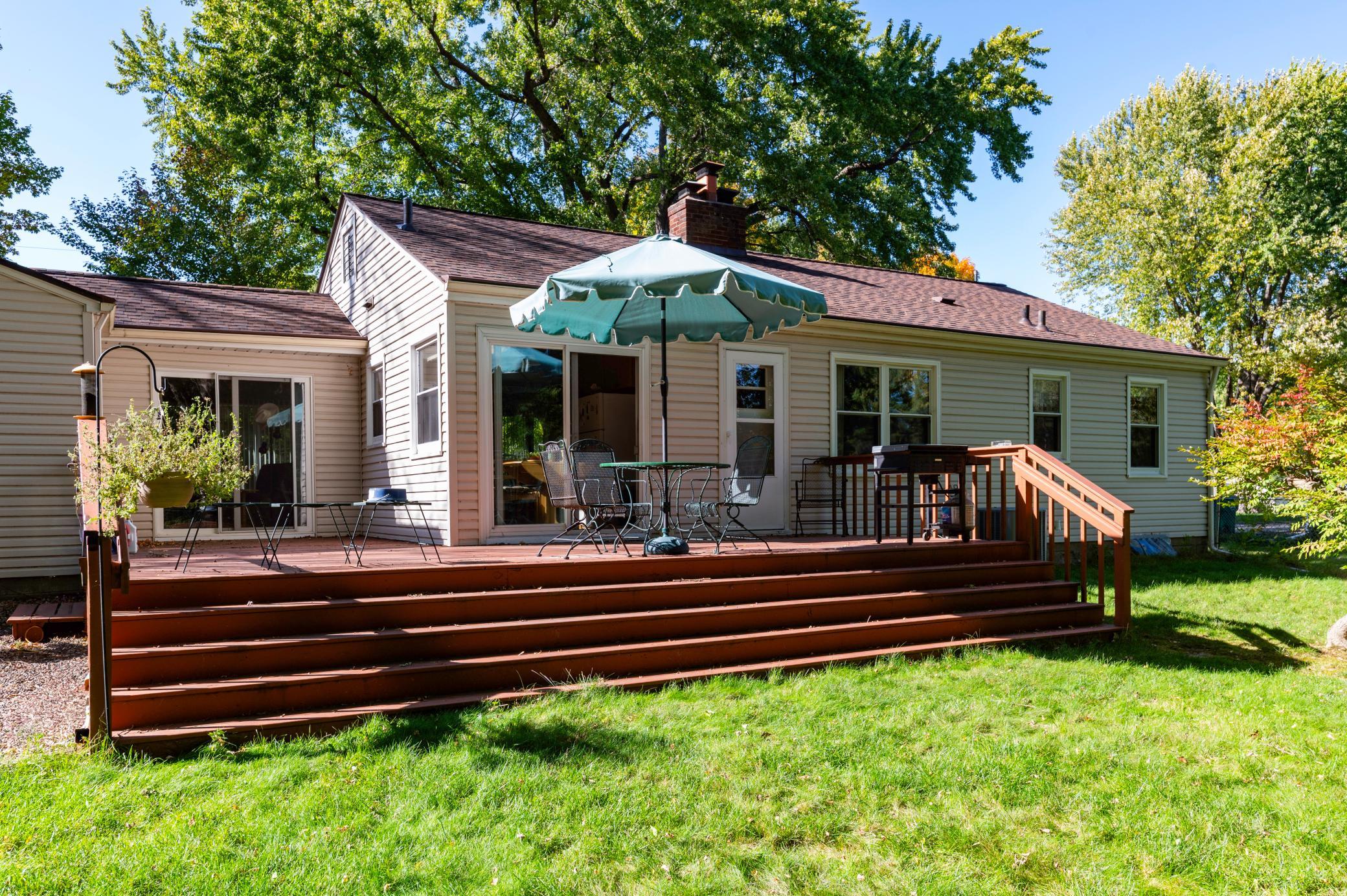 Backyard view of home showing the size of the large deck and two patio slider doors.